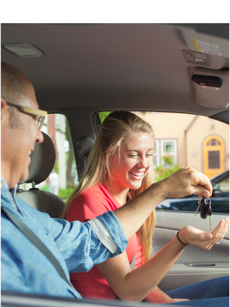 A smiling woman in the drivers seat of a car