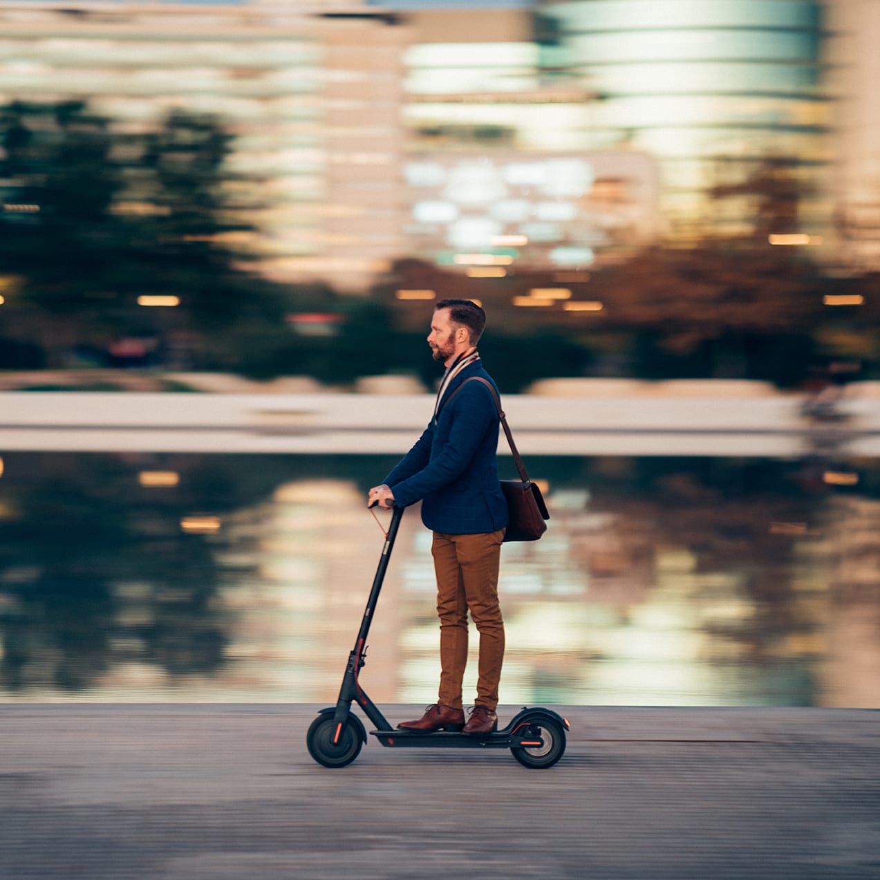 Profile view of businessman riding a scooter on his way to work