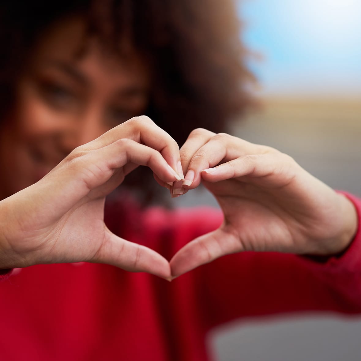 Cropped shot of an unrecognizable woman forming a heart shape with her fingers