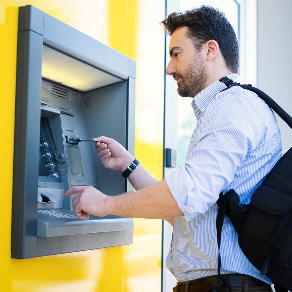 Man using a credit card in an atm for cash withdrawal
