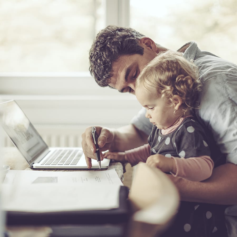 Fahter is showing his daughter things on a laptop