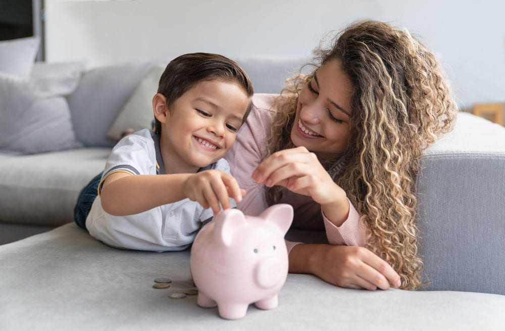 regularsavings mom and daughter adding savings to piggy bank