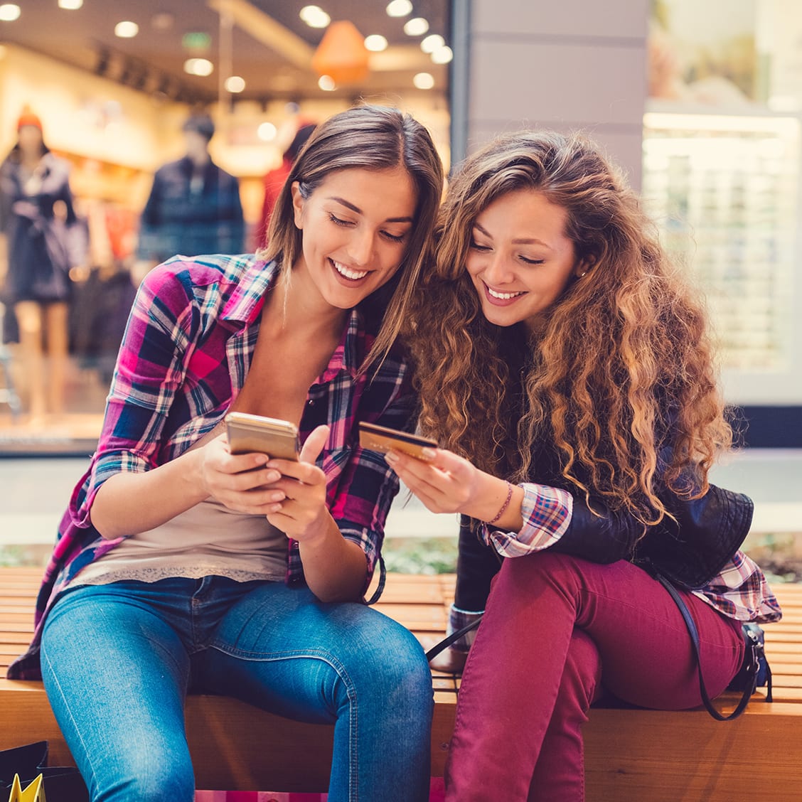 This appears on hover Young women in the mall using credit card for online shopping +++++ Note for the inspector : Credit card is fake and made especially for the photosession +++++