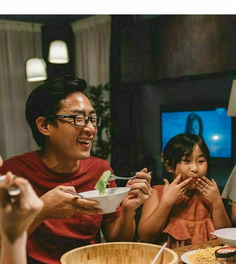 Happy family passing food around the dinner table