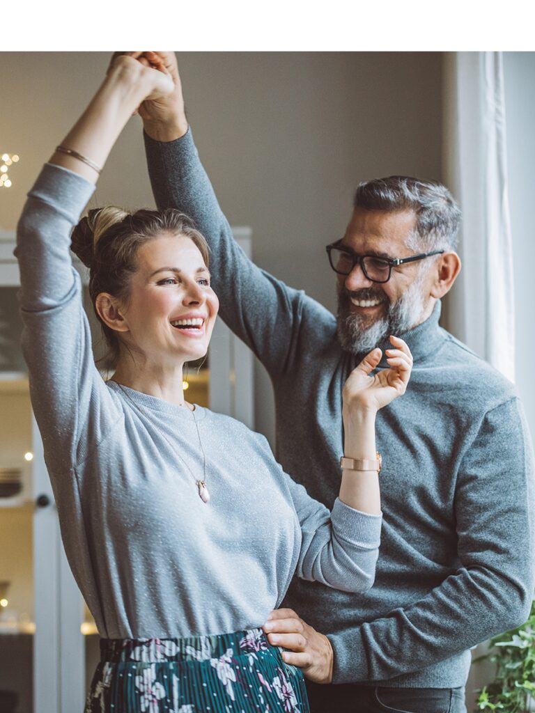 Photo of a woman and a man happily dancing.