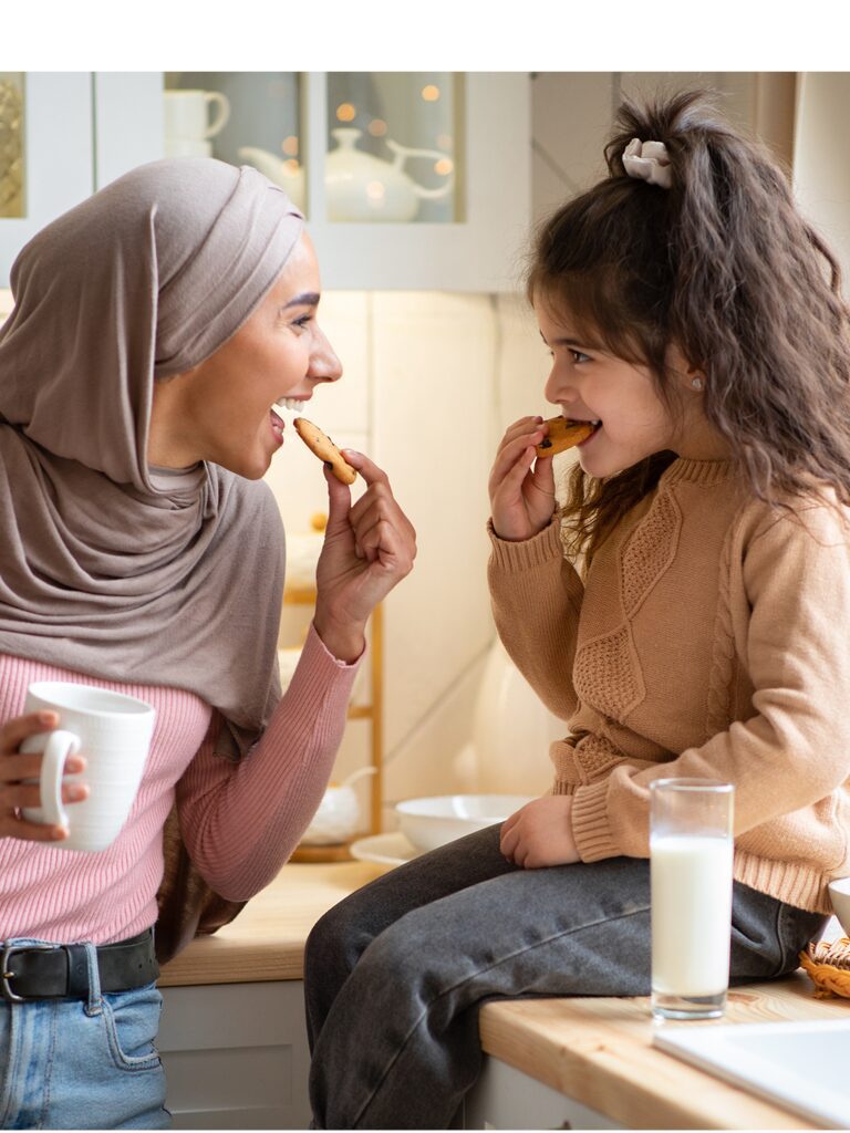 Image of a mother and child facing each other. They are each taking a bite out of a cookie.
