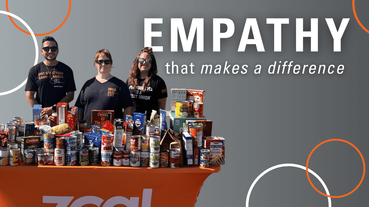 Carousel_Careers_Empathy Zeal Branch Team Members standing with a table full of food drive donations. Caption reads "EMPATHY that makes a difference."