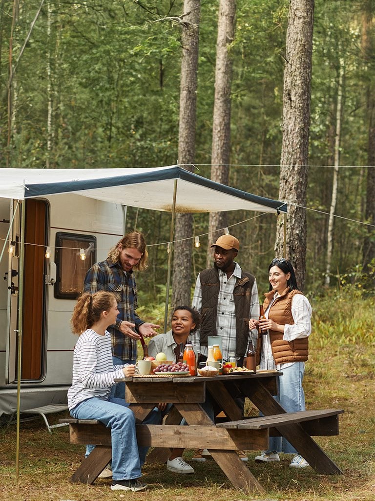 Photo of a family at a picnic table near their camper