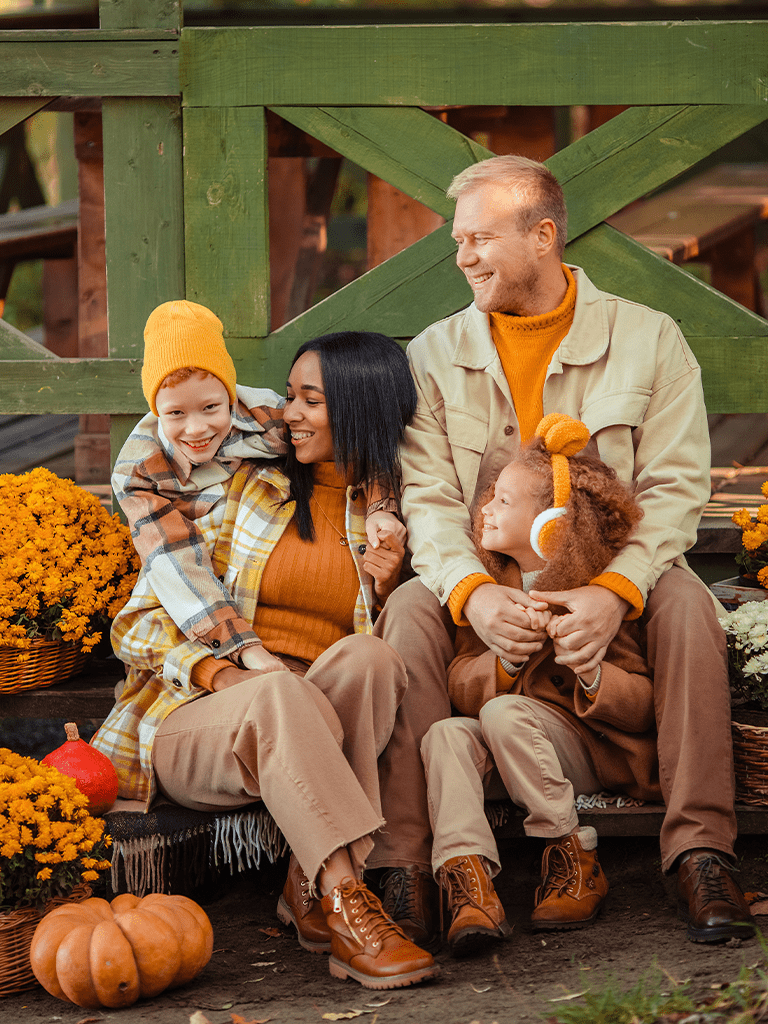 A family of fouraresitting outside on a fall day